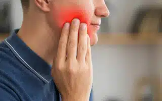 A man with toothache having painful area highlighted in red